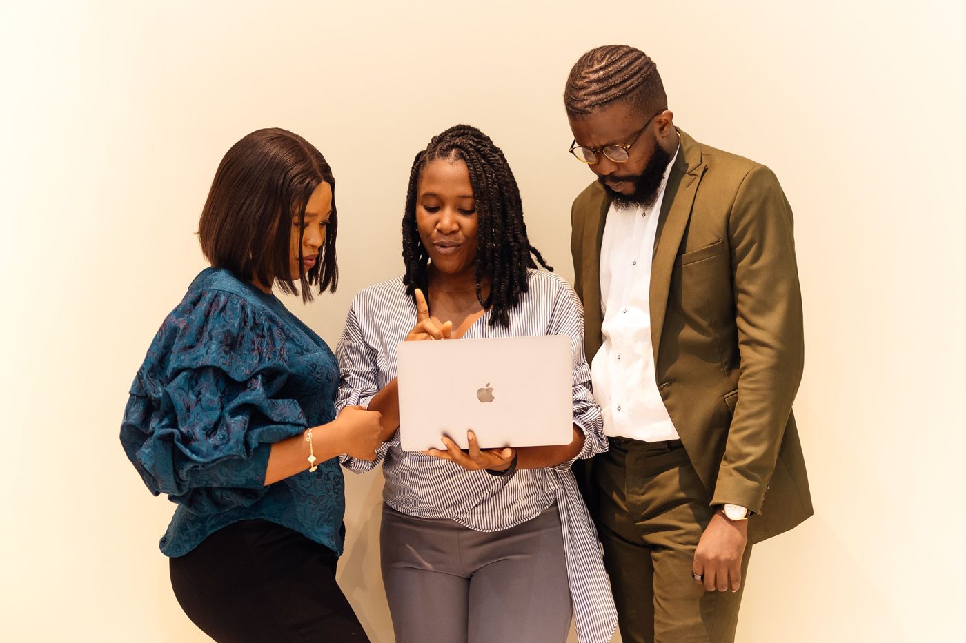 Professionals collaborate around a laptop in Lagos.
